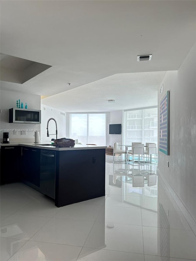 kitchen featuring sink, floor to ceiling windows, and light tile patterned floors