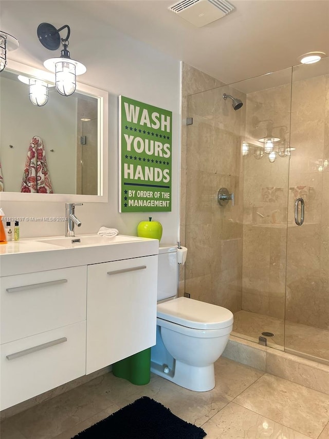 bathroom with tile patterned flooring, an enclosed shower, vanity, and toilet