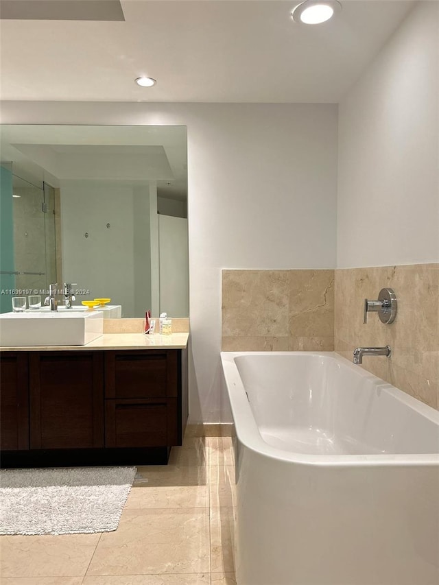 bathroom featuring tile patterned flooring, a tub to relax in, and vanity