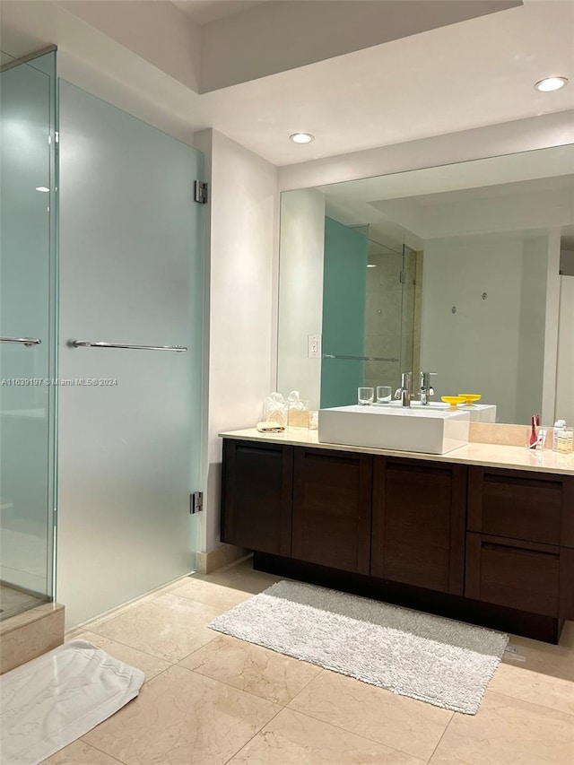 bathroom featuring tile patterned floors, vanity, and a shower with shower door