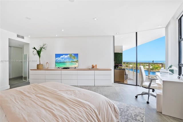 bedroom featuring expansive windows and access to exterior