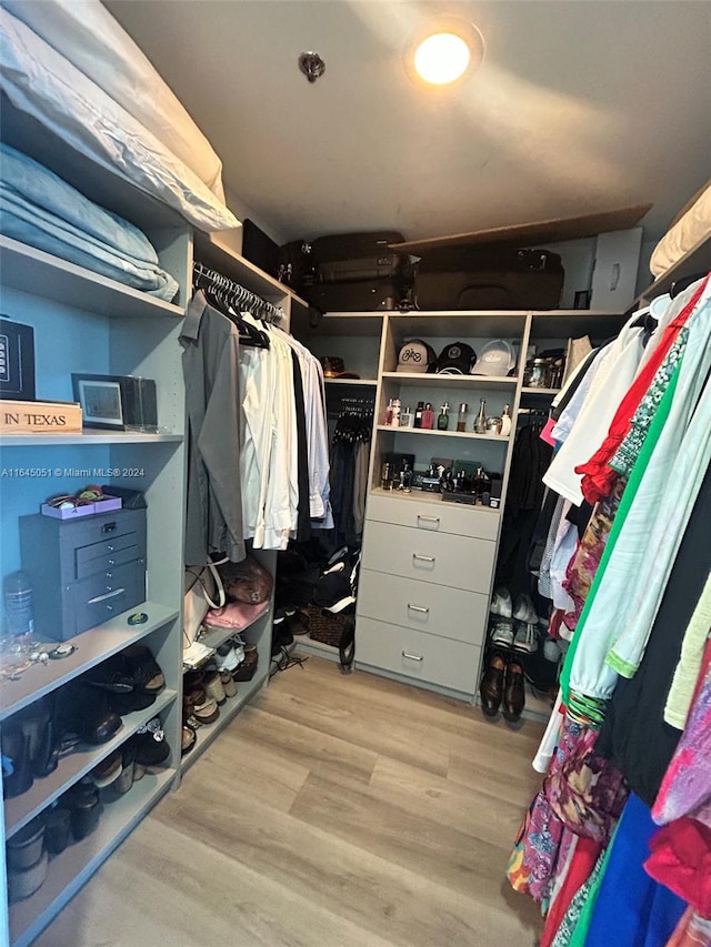 walk in closet with light hardwood / wood-style flooring