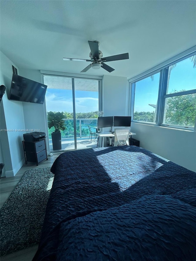 bedroom featuring ceiling fan, multiple windows, access to exterior, and light wood-type flooring