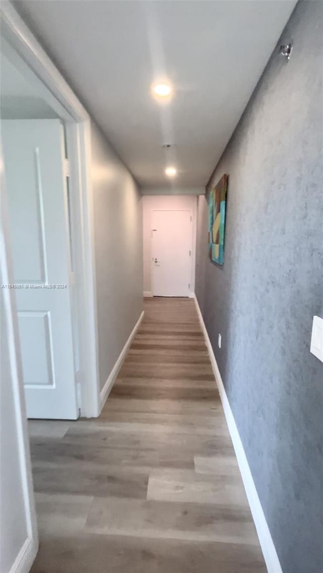 corridor with hardwood / wood-style flooring