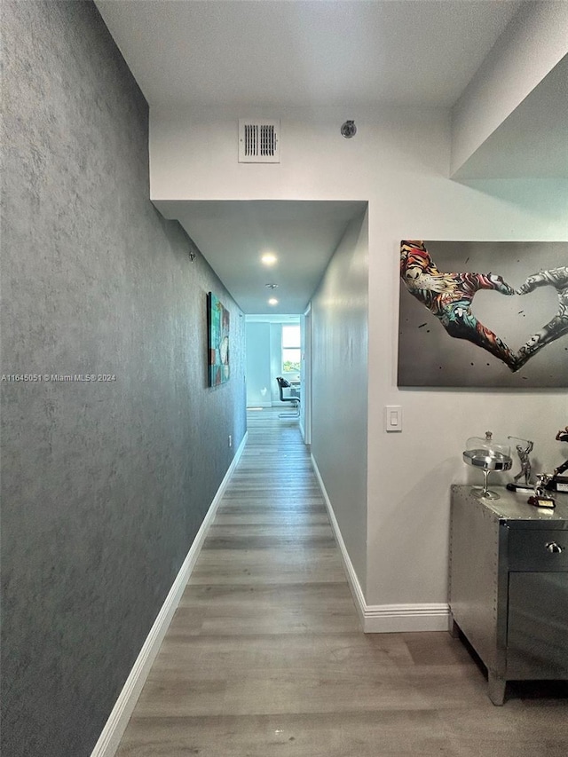 corridor with hardwood / wood-style flooring