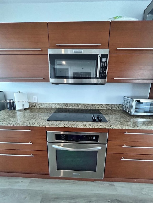 kitchen with stone counters and appliances with stainless steel finishes