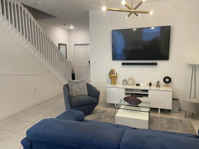 tiled living room featuring a notable chandelier