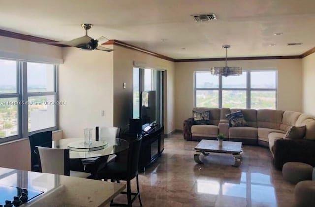 tiled living room featuring ceiling fan with notable chandelier and ornamental molding