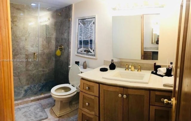 bathroom featuring tile patterned flooring, a shower with door, toilet, and vanity