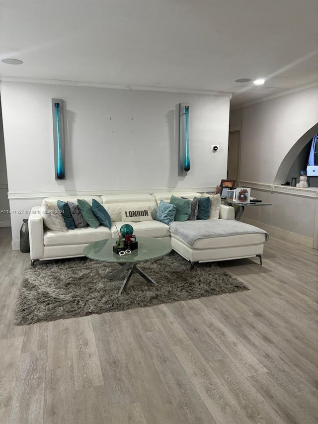 living room featuring light wood-type flooring and ornamental molding