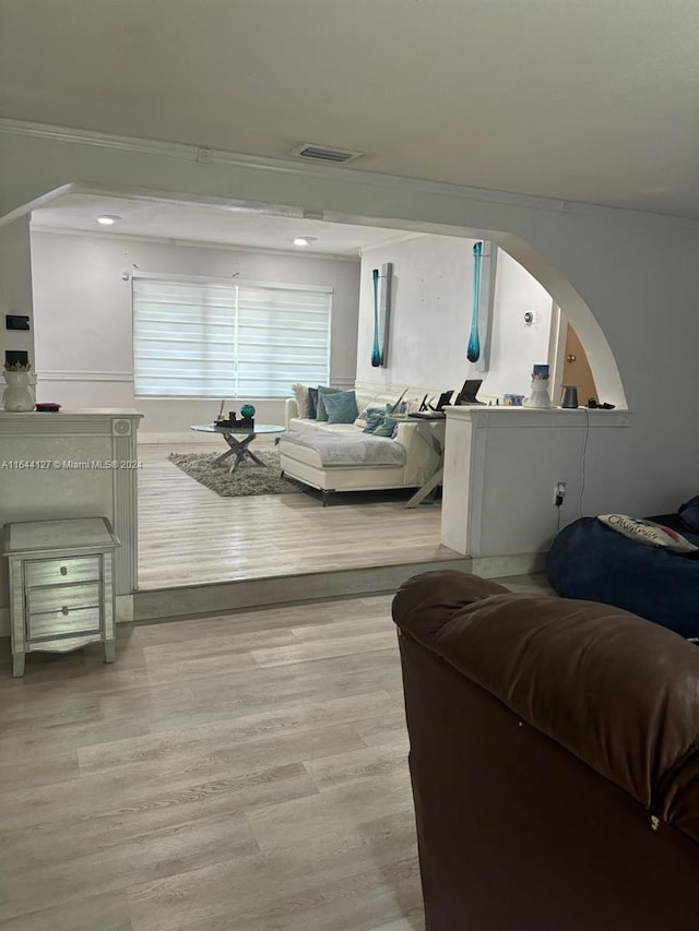 living room featuring light hardwood / wood-style flooring and ornamental molding