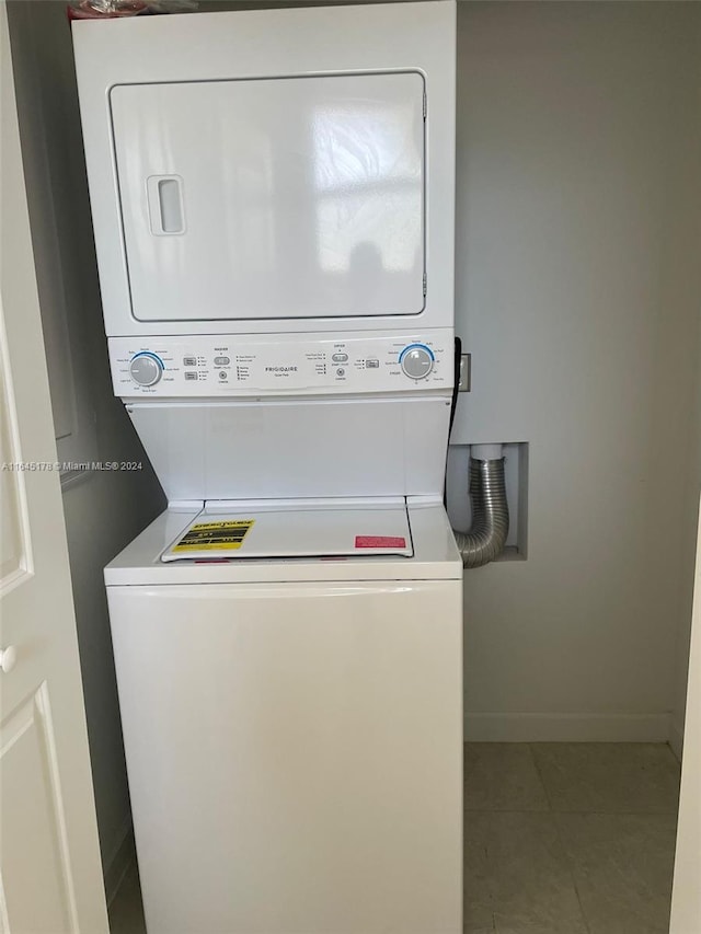 laundry area featuring tile patterned flooring and stacked washing maching and dryer