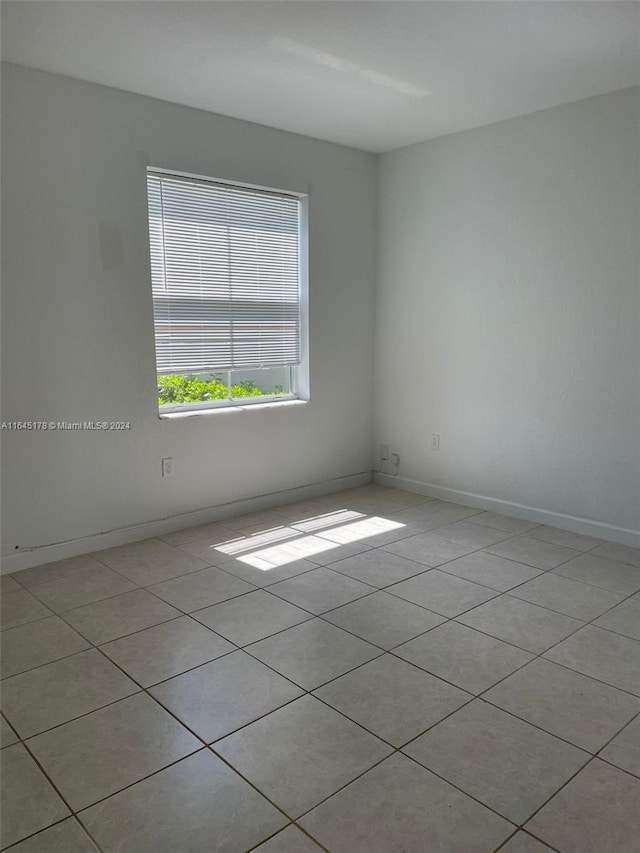 spare room featuring light tile patterned flooring