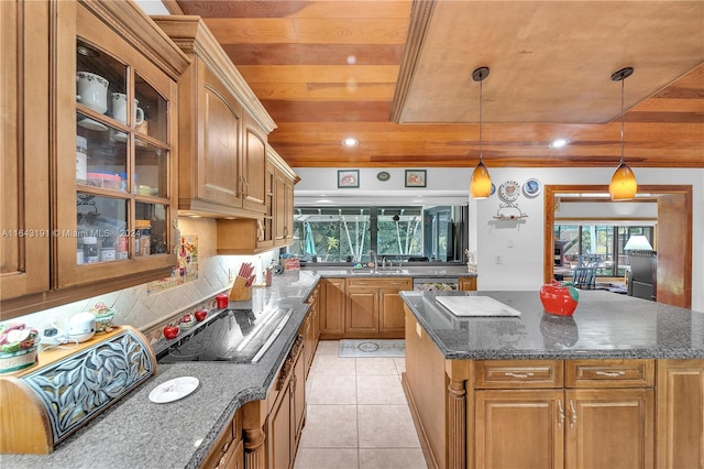 kitchen featuring a center island, dark stone countertops, sink, and backsplash