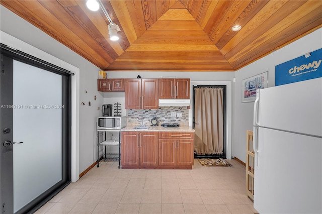 kitchen featuring light tile patterned flooring, a raised ceiling, wooden ceiling, and white fridge