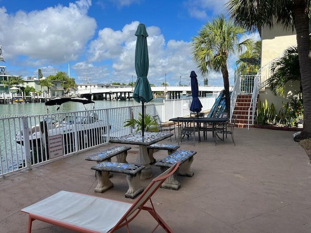 8420 Byron Ave Unit 4, Miami Beach, FL 33141 - view of patio featuring outdoor dining area, stairway, and a water view