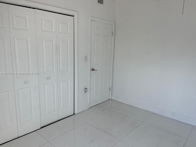 unfurnished bedroom featuring a closet and light tile patterned flooring