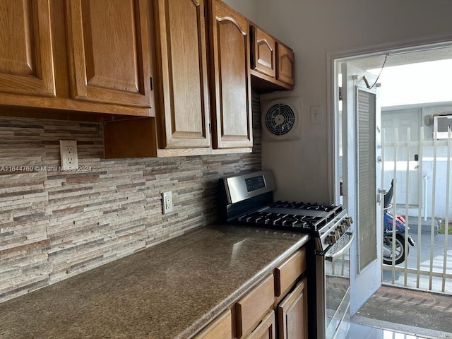 kitchen with gas stove, decorative backsplash, and tile patterned floors