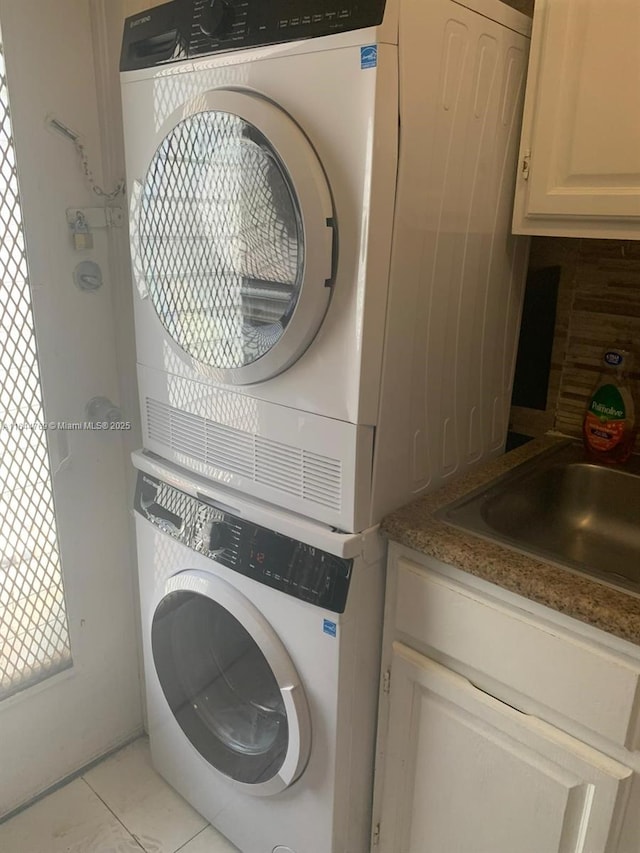 8420 Byron Ave Unit 4, Miami Beach, FL 33141 - washroom with stacked washer and clothes dryer, cabinet space, and light tile patterned flooring