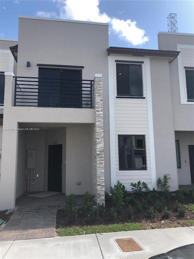 view of front facade featuring a balcony and stucco siding