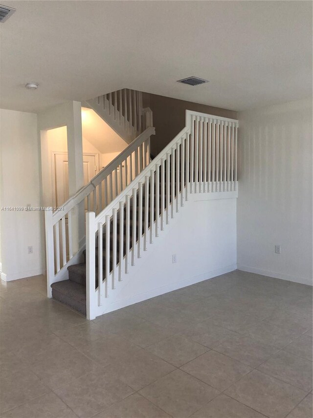 staircase with tile patterned floors