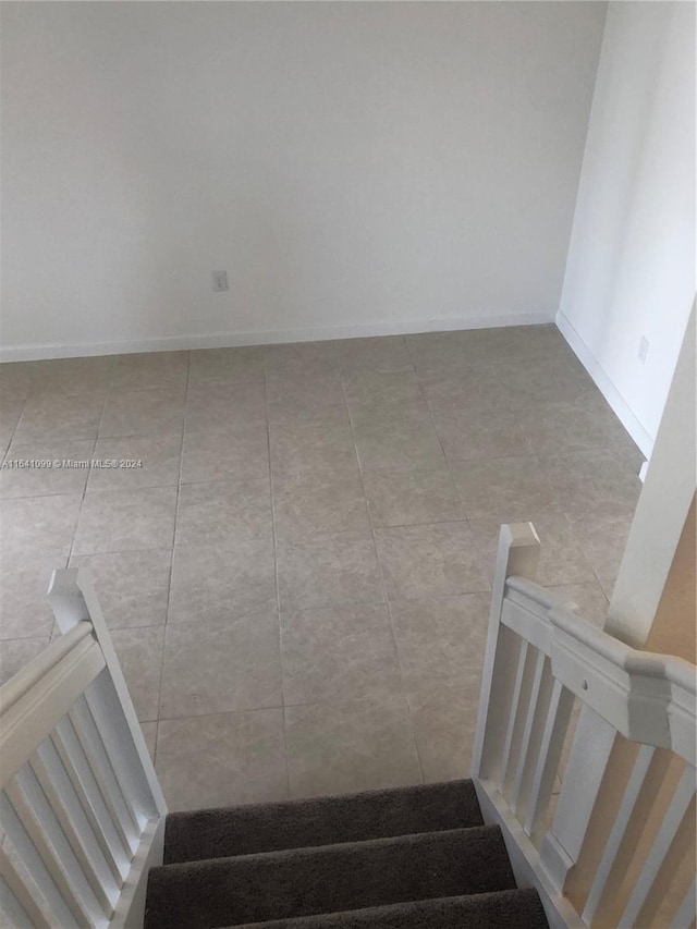 staircase featuring baseboards and tile patterned floors