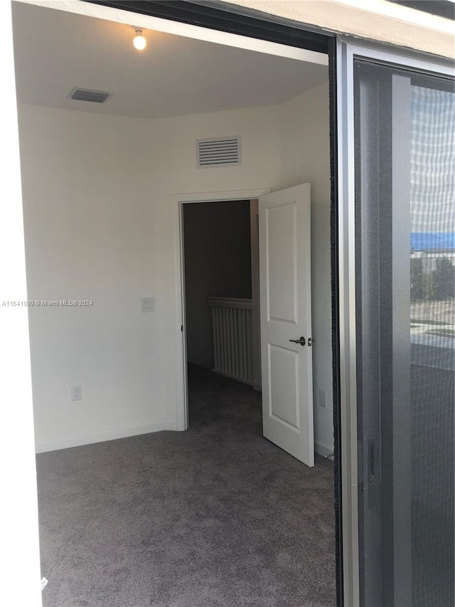 carpeted empty room featuring visible vents and baseboards