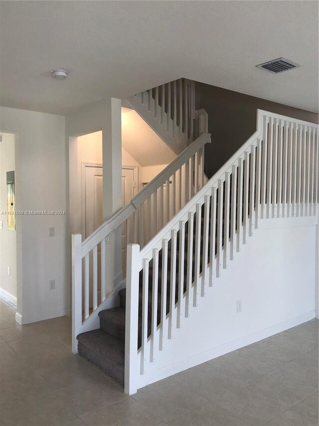 stairway with tile patterned floors