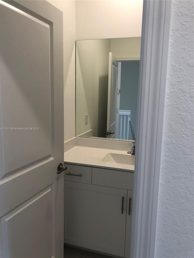 bathroom featuring a textured wall and vanity