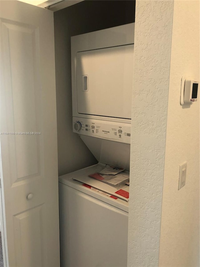 washroom featuring stacked washer and clothes dryer