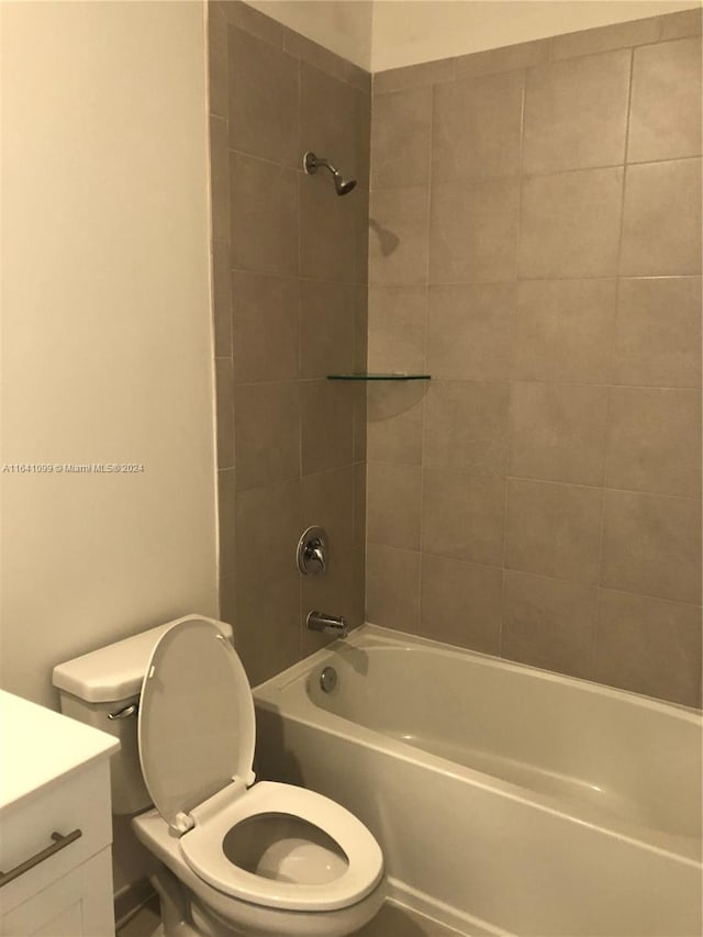 full bathroom with vanity, tiled shower / bath combo, and toilet