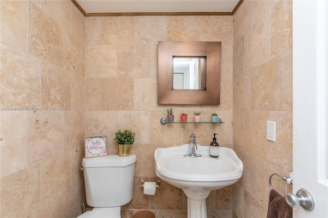 bathroom featuring tile walls, sink, crown molding, and toilet