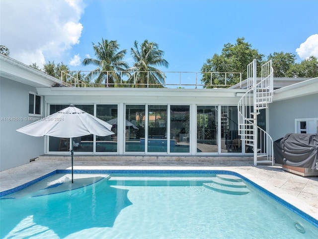 view of pool with area for grilling and a patio area