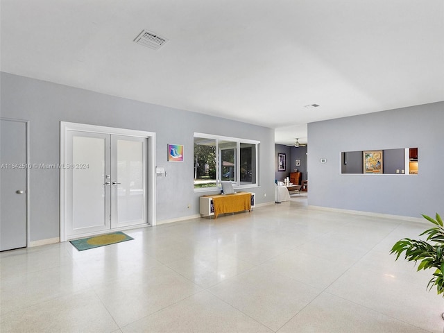 unfurnished living room with french doors and ceiling fan