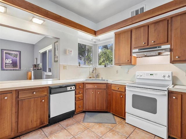 kitchen with sink, light tile patterned floors, and white appliances