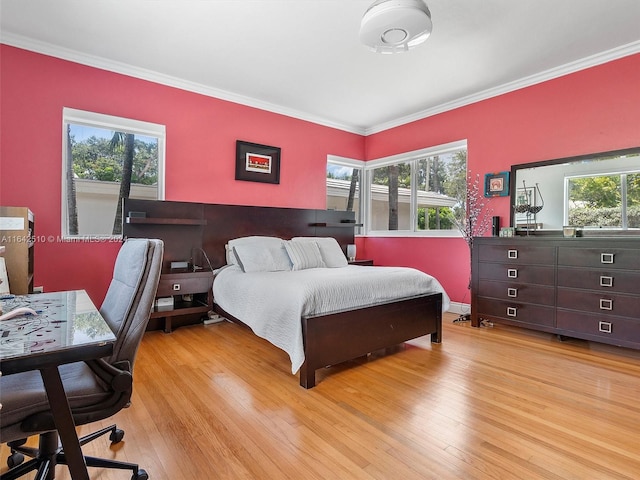 bedroom featuring light hardwood / wood-style floors, multiple windows, and crown molding