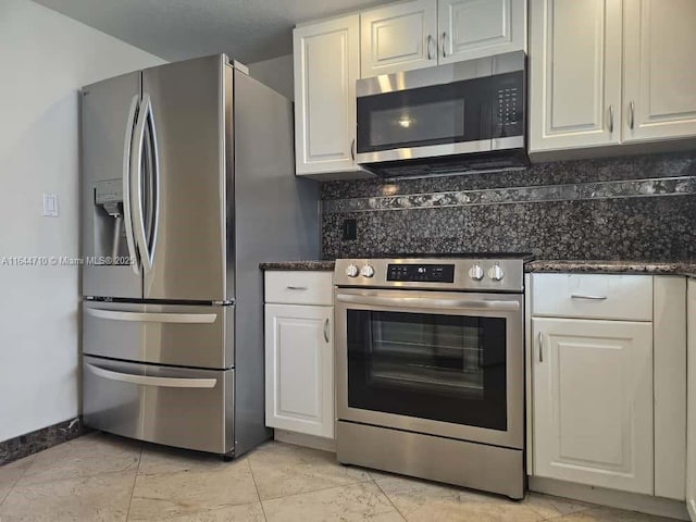 1650 Coral Way Unit 601, Miami, FL 33145 - kitchen with stainless steel appliances, tasteful backsplash, white cabinetry, and dark stone counters