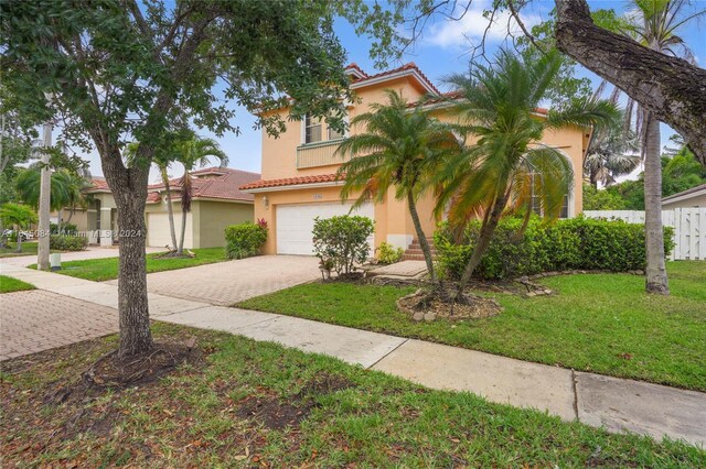 mediterranean / spanish-style house with a garage and a front yard