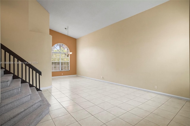 tiled spare room with lofted ceiling