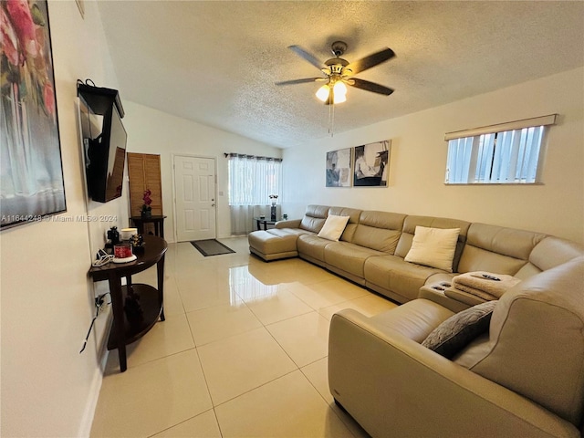 living room with ceiling fan, light tile patterned floors, a textured ceiling, and vaulted ceiling