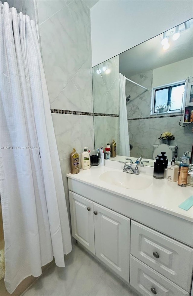 bathroom with vanity, tile walls, and curtained shower