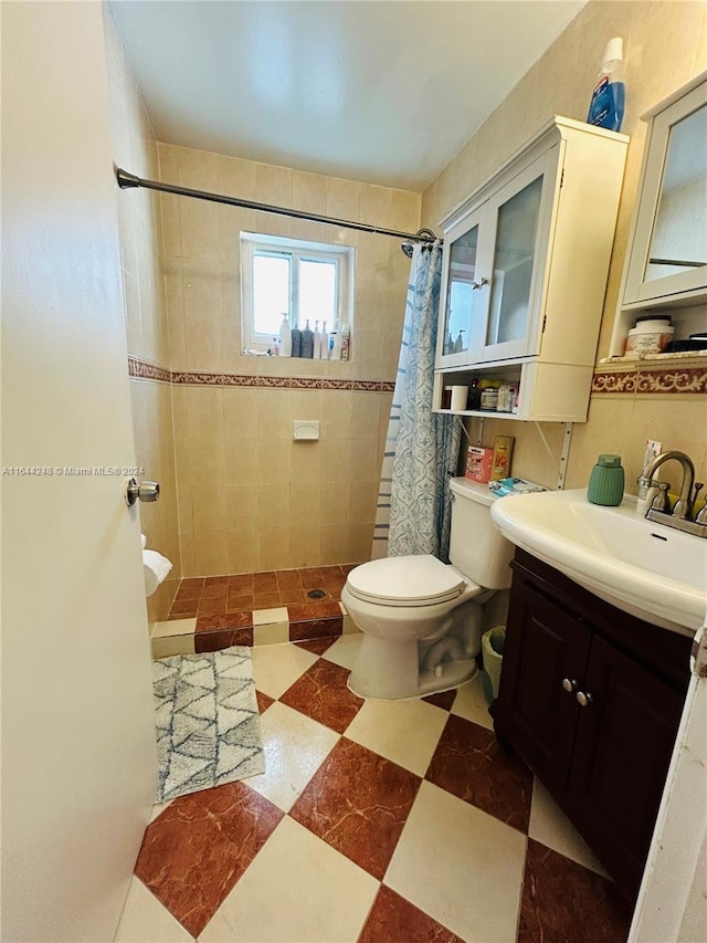 bathroom featuring toilet, vanity, tile walls, and a shower with shower curtain