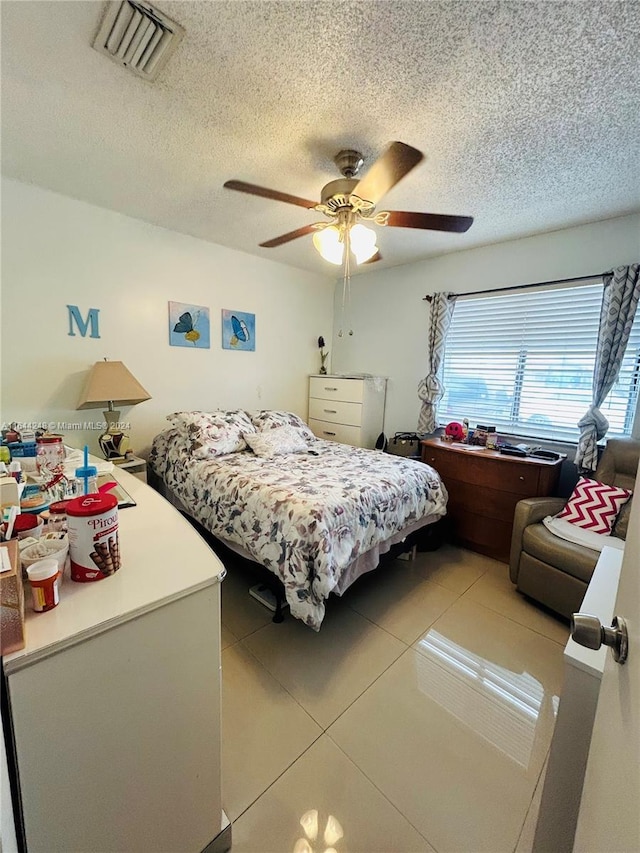 bedroom with light tile patterned floors, a textured ceiling, and ceiling fan