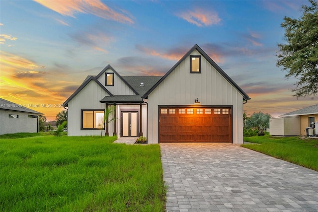 modern farmhouse style home with a garage and a lawn