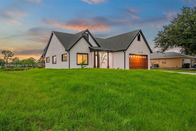 modern farmhouse featuring a lawn and a garage