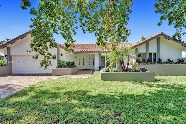 mediterranean / spanish house with a garage and a front yard