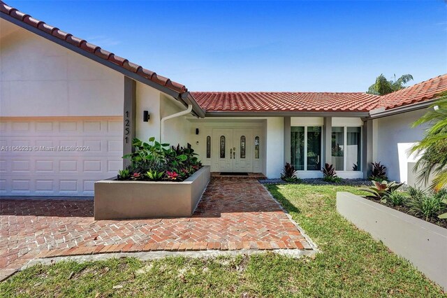 mediterranean / spanish house featuring a front yard and a garage