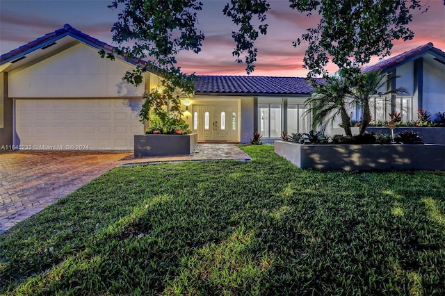 view of front of home with a lawn and a garage