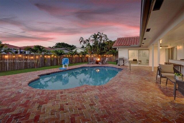 pool at dusk with a patio