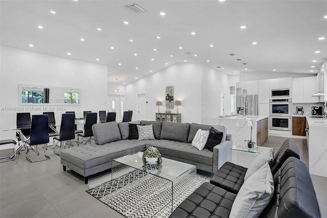 living room with light tile patterned flooring and high vaulted ceiling